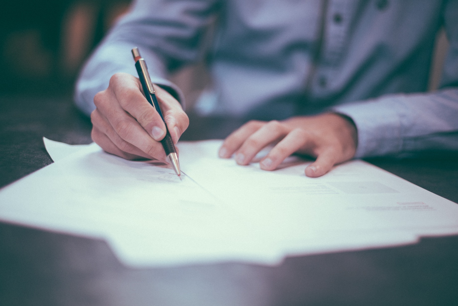 A person signing documents that they will need to scan with VueScan